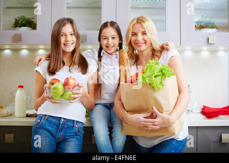 Porträt der glückliche Mutter und zwei Töchter, Blick in die Kamera in der Küche Stockfoto