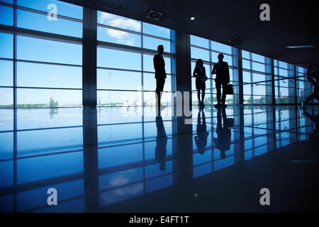 Silhouetten von mehreren Büroangestellte am Fenster stehend Stockfoto