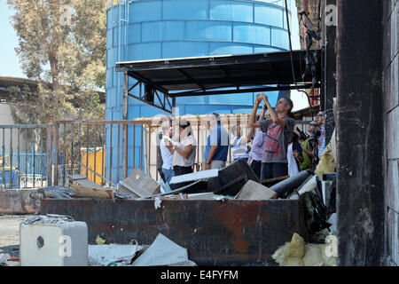 Sderot, Israel. 10. Juli 2014. Ausländische Journalisten bereisen die südlichen israelische Stadt Sderot erleben Sie hautnah das Ertönen der "Farbe rot" Benachrichtigung anfliegenden Raketen aus dem Gazastreifen und Zuflucht unter den Ruinen von einem Sderot Lackfabrik direkt getroffen und zerstört nur eine Woche zuvor. Bildnachweis: Nir Alon/Alamy Live-Nachrichten Stockfoto