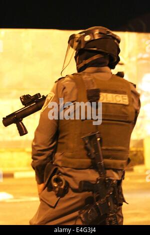 BETHLEHEM, WEST BANK Palästina - 2014/07/09-ein israelischer Soldat bekommt ein Tränengas-Behälter in eine Menge von palästinensischen Jugendlichen schussbereit. Für die acht Nacht hintereinander brachen intensiven Auseinandersetzungen in Bethlehem in der Nähe von Rachels Grab, auch bekannt als Prüfpunkt 300. In dieser Nacht warfen palästinensische Jugendlichen mit Steinen aus einer anderen Straße, die zu den militärischen Wartturm führt. Gewalt hat nicht aufgehört, seit letzter Woche Beerdigung von Muhammad Abu Khdeir und es gibt keine Anzeichen, die es in den kommenden Wochen sterben wird, ab. Seit Israels Eskalation und militärischen Einmarsch in Gaza genannt "Fels in der Brandung" Resenment in Richtung t Stockfoto