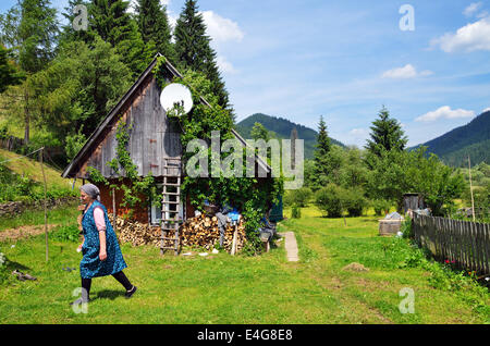Ältere Frau im Hof ihres Hauses in Karpaten, Ukraine Stockfoto
