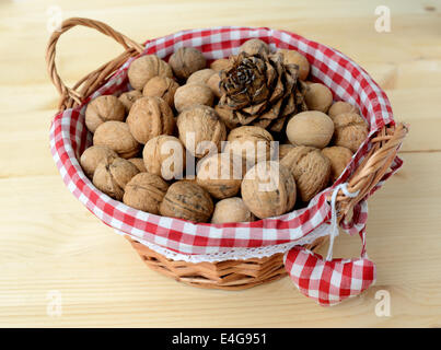 Korb mit Nüssen auf einem Holztisch. Stockfoto