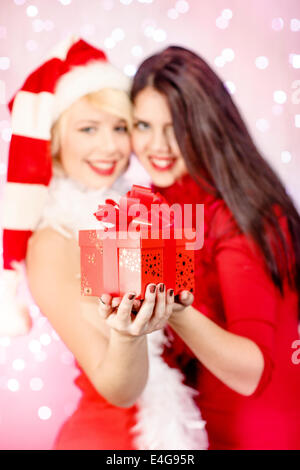 Junge Frau im Weihnachtsmann-Kostüm mit Geschenk-box Stockfoto