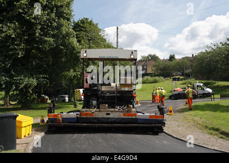 Straßenrenovierungsarbeiten in einer Vorstadtstraße in Sheffield England. Männer, die Straßenreparaturen durchführen Stockfoto