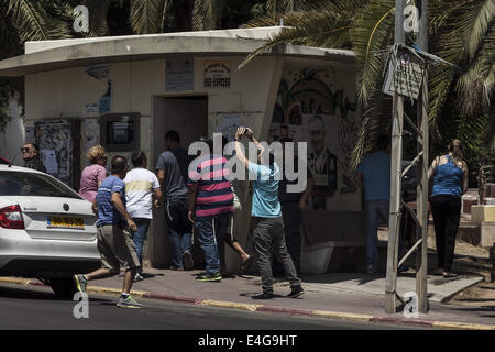 Sderot, Israel. 10. Juli 2014. Israelis führen zu einer befestigten Bushaltestelle '' Tzeva Adom'' (Alarmstufe rot) klingt in den Straßen von Sderot auf 10. Juli 2014, Signalisierung ein weiteres Raketenbeschuss aus dem Gazastreifen. Als Israel den Küstenstreifen bombardiert und eine Bodeninvasion bereitet, sind Hunderte von Raketen jeden Tag von der Hamas ins Leben gerufen. Bildnachweis: Janos Chiala/NurPhoto/ZUMA Draht/Alamy Live-Nachrichten Stockfoto