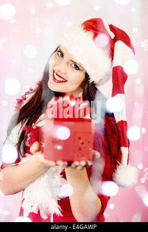 Junge Frau im Weihnachtsmann-Kostüm mit Geschenk-box Stockfoto