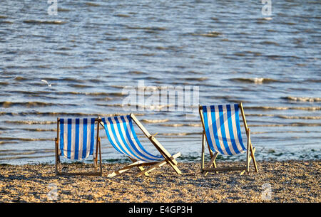 Drei leere Liegestühle am Strand Jubiläum in Southend. Stockfoto