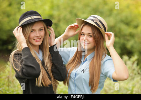 Zwei britische Schulmädchen Uniform und Hüte tragen. Stockfoto