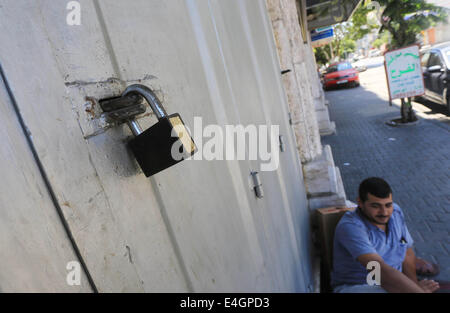 Gaza-Stadt, Gazastreifen, Palästinensische Gebiete. 11. Juli 2014. Ein palästinensischer Mann sitzen auf einer Haupteinkaufsstraße mit Fensterläden Läden in der Innenstadt von Gaza-Stadt, am 11. Juli 2014. Aufgrund der Situation sind die Straßen von Gaza während des ganzen Tages, Menschen sind Angst, da in der Regel gehen und lieber zu Hause bleiben leer. Israel drückte auf einen vierten Tag mit der Gaza-Offensive am Freitag, die Hamas dominierten Enklave von Luft- und Seefracht, auffällig, wie palästinensische militante aufrechtgeerhalten Angriffe tief Rakete in den jüdischen Staat. Bildnachweis: ZUMA Press, Inc./Alamy Live-Nachrichten Stockfoto