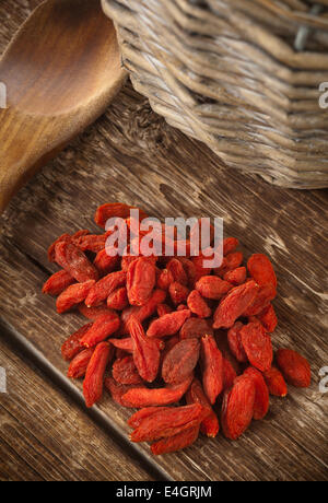 Getrocknete Goji-Beeren isoliert auf Holztisch. Stockfoto