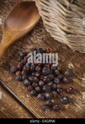 Handvoll Wacholderbeeren isoliert auf Holztisch. Stockfoto