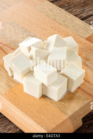 Frischer Tofu-Würfel auf Holzbrett. Stockfoto