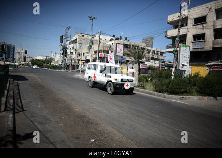 Gaza, Gazastreifen, Palästinensische Gebiete. 11. Juli 2014. Eine Autofahrt auf entlang einer Haupteinkaufsstraße mit Fensterläden Läden in der Innenstadt von Gaza-Stadt, am 11. Juli 2014. Aufgrund der Situation sind die Straßen von Gaza während des ganzen Tages, Menschen sind Angst, da in der Regel gehen und lieber zu Hause bleiben leer. Israel drückte auf einen vierten Tag mit der Gaza-Offensive am Freitag, palästinensischen militanten aufrechtgeerhalten Rakete hat auffällig der Hamas dominierten Enklave von Luft- und Seefracht, greift tief in den jüdischen Staat. Bildnachweis: ZUMA Press, Inc./Alamy Live-Nachrichten Stockfoto