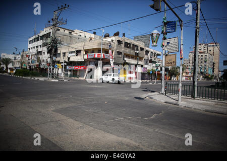 Gaza, Gazastreifen, Palästinensische Gebiete. 11. Juli 2014. Eine Autofahrt auf entlang einer Haupteinkaufsstraße mit Fensterläden Läden in der Innenstadt von Gaza-Stadt, am 11. Juli 2014. Aufgrund der Situation sind die Straßen von Gaza während des ganzen Tages, Menschen sind Angst, da in der Regel gehen und lieber zu Hause bleiben leer. Israel drückte auf einen vierten Tag mit der Gaza-Offensive am Freitag, palästinensischen militanten aufrechtgeerhalten Rakete hat auffällig der Hamas dominierten Enklave von Luft- und Seefracht, greift tief in den jüdischen Staat. Bildnachweis: ZUMA Press, Inc./Alamy Live-Nachrichten Stockfoto