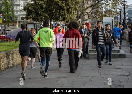 Pendler läuft Heimweg von der Arbeit auf eine Süd-Ufer promenade auf der Themse in der Nähe von Lambeth, London UK Stockfoto