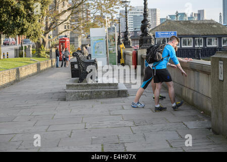 Jogger Läufer warm Strecke auf einem geführten Heim von der Arbeit an einem Frühlingsabend, Themse, Lambeth, London UK Stockfoto