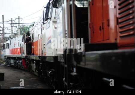 Jakarta, Indonesien. 11. Juli 2014. Ein Arbeiter reinigt eine Lokomotive in Vorbereitung für Eid al-Fitr Festival in einem Pflege-Werk in Jakarta, Indonesien, 11. Juli 2014. Jedes Jahr Indonesiens Verkehr erreicht ihren Höhepunkt während der Reisezeit, wie Millionen von Menschen in ihre Heimatorte mit dem Flugzeug reisen, Schiff, Auto oder Motorrad, das Eid al-Fitr-fest zu feiern. © Zulkarnain/Xinhua/Alamy Live-Nachrichten Stockfoto