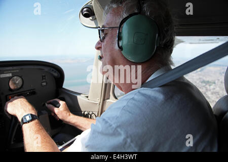ein Pilot namens David Hockings an den Schalthebeln der seine Cessna C172 fliegen über Essex Stockfoto