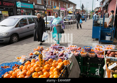 Zwei muslimische Frauen vorbeigehen ein Gemüsehändler im Zentrum des Gebiets vor allem asiatische Lozells in Birmingham, UK Stockfoto