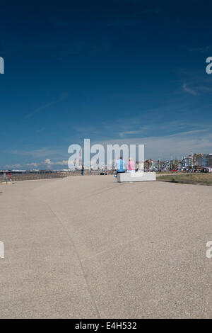 Genießen Sie die Sonne auf Blackpools neue Promenade sitzen ein paar Stockfoto
