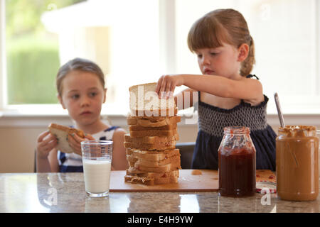 Zwei Mädchen, stapeln, Erdnussbutter und Gelee sandwiches Stockfoto