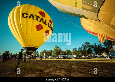 Igualada, Spanien. 10. Juli 2014: Heißluftballons vorzubereiten, für den ersten Wettbewerb von Igualada Flug Bereich. abzuweichen - die ersten Wertungsflüge der 18. Ausgabe von Igualada vier Tage langen europäischen Ballon-Festival, die größte Konzentration, Wettbewerb und Festival von Heißluft Ballons in Spanien mit mehr als 50 internationale Teams dauerte nicht sehr lange wegen starkem Wind Stockfoto