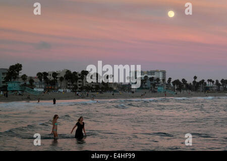 Venedig, Kalifornien, USA. 11. Juli 2014. Frauen waten im Pazifischen Ozean, wie der super am 11. Juli über Venice Beach Mondaufgang. 2014 hat insgesamt fünf Supermoons, die zwei Neumonde Januar und die Vollmonde, Juli, August und September. Bildnachweis: Jonathan Alcorn/ZUMA Draht/Alamy Live-Nachrichten Stockfoto