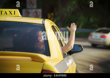 Menschen reisen. Beifahrerin im Taxi mit Arm außerhalb Autofenster Hand winken. Begriff der Freiheit Stockfoto