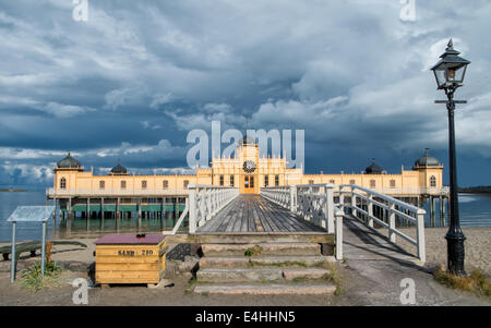 Die Sonne bricht durch dunkle Wolken, auf der berühmten Volksbad in Varberg, Schweden glänzen. Stockfoto