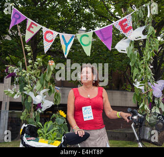 West Kirkby, Wirral, Großbritannien. 12th. Juli 2014. Mrs Letty Curtis mit Recycle Bike, trägt 2nd Handkleidung, Recycling von Second-Hand-Kleidung bei der Open Golf Big Welcome Parade. Stockfoto