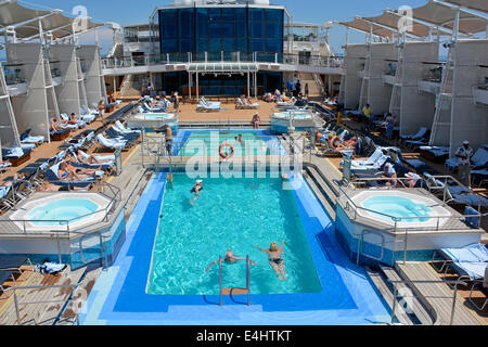 Menschen in Ocean Cruise Liner Schiff schwimmen im Pool und entspannen Sie auf der Liegewiese mit Liegestühlen Adria vor der Küste von Italien Europa Stockfoto