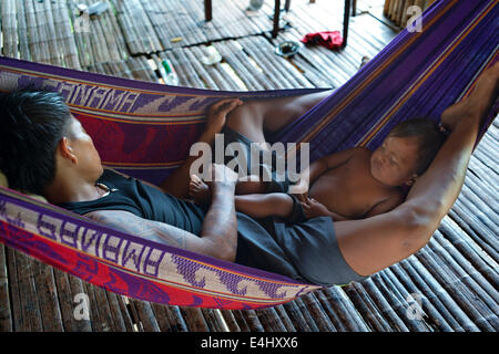 Männer und seinem Kind eine Siesta in einer Hängematte im Dorf des Stammes Native Indian Embera, Embera Dorf, Panama zu tun. Panama Stockfoto