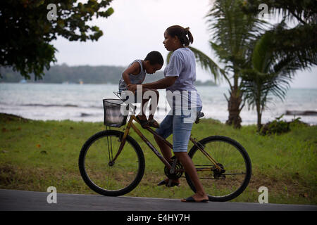 Mutter mit seinem Kind in ein Fahrrad. Bocas del Toro, Panama. Bocas del Toro (Bedeutung "Mund des Stiers") ist eine Provinz von Panama. Stockfoto