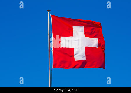 Schweizer Flagge gegen blauen Himmel Stockfoto