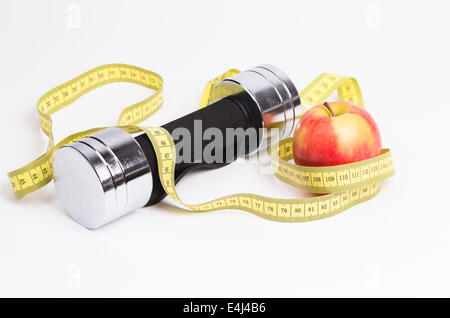 Bild zeigt ein einer Langhantel ein Maßband und einen frischen Apfel Stockfoto