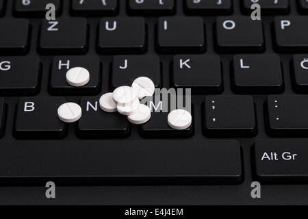 Bild zeigt einen Haufen Pillen auf einer Tastatur Stockfoto