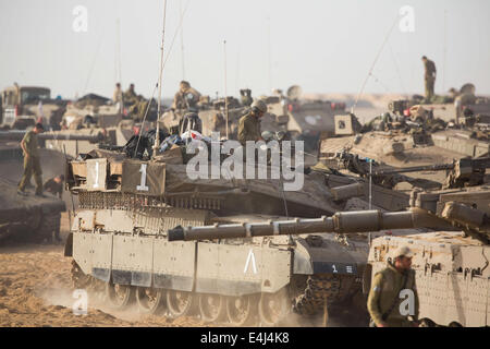 Gaza-Grenze. 13. Juli 2014. Israelische Soldaten arbeiten auf ihre Merkava-Kampfpanzer in einem Armee-Bereitstellung-Gebiet im Süden Israels nahe der Grenze zu Gaza, am fünften Tag der Operation in der Brandung, 12. Juli 2014. Israel hat nicht die Absicht, die Luftangriffe auf Gaza in den kommenden Tagen zu stoppen, israelische Verteidigungsminister Moshe Ya'alon sagte Army Radio am Samstag, als der internationale Druck auf einen Waffenstillstand auszuhandeln, in dem Konflikt sammeln Tempo. Bildnachweis: Xinhua/Alamy Live-Nachrichten Stockfoto