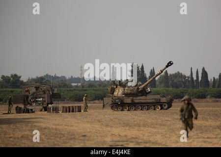 Gaza-Grenze. 13. Juli 2014. Eine israelische 155mm M109 Dores Panzerhaubitze (R) ist im Süden Israels nahe der Grenze zu Gaza, am fünften Tag der Operation in der Brandung, am 12. Juli 2014 positioniert. Israel hat nicht die Absicht, die Luftangriffe auf Gaza in den kommenden Tagen zu stoppen, israelische Verteidigungsminister Moshe Ya'alon sagte Army Radio am Samstag, als der internationale Druck auf einen Waffenstillstand auszuhandeln, in dem Konflikt sammeln Tempo. Bildnachweis: Xinhua/Alamy Live-Nachrichten Stockfoto