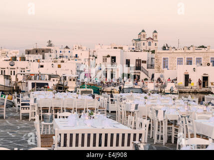 Tische für das Abendessen in der Waterfront Taverne Naoussa Stadt, Insel Paros, Kykladen, Griechenland Stockfoto