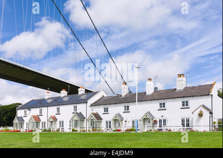 Eine Reihe von schönen Hütten unter das imposante Bauwerk der Humber-Brücke an einem feinen Sommermorgen in der Nähe Stockfoto