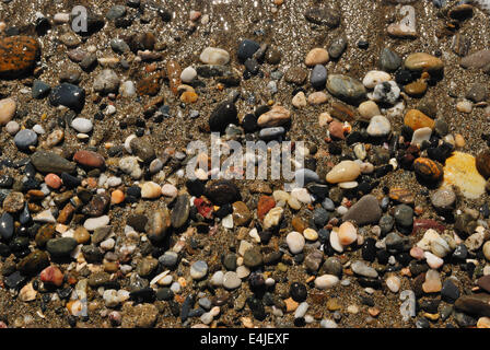Hintergrund von kleinen Steinen am Ufer am Strand Stockfoto