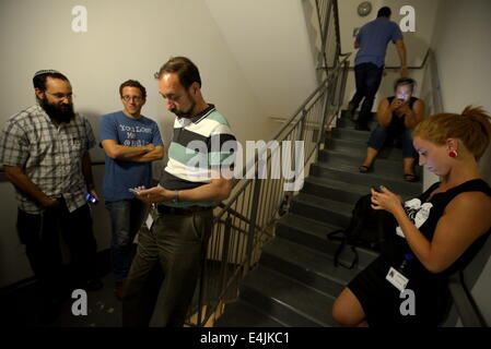 Anana, Israel. 13. Juli 2014. Israelis gehen in Deckung in einer Treppe mit ein Gebäude wie ein Code Red Büros Sirene ertönt Warnung des ankommenden Raketen in Ra'anana, 13. Juli 2014. In den letzten sechs Tagen wurden über 500 Raketen aus dem Gazastreifen auf Israel abgefeuert. Bildnachweis: Gili Yaari/NurPhoto/ZUMA Draht/Alamy Live-Nachrichten Stockfoto