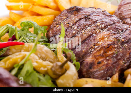 Gesunde Platte mit gemischtem Fleisch einschließlich gegrilltes Steak, knusprig Panierter Hühner- und Rindfleisch auf einem Bett aus frischen grünen grünen gemischten sa Stockfoto