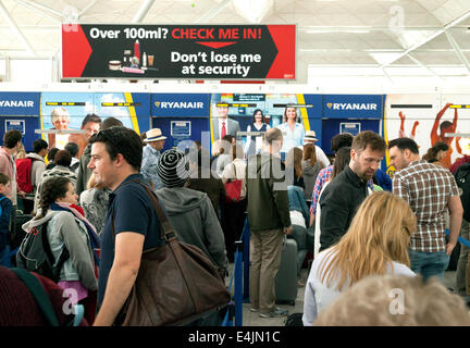 Passagier-Warteschlange bei Ryanair Check-in-Schalter, Flughafen Stansted, London UK Stockfoto