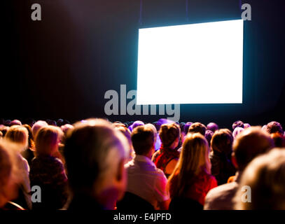 Menge Publikum im dunklen Blick auf heller Bildschirm Stockfoto