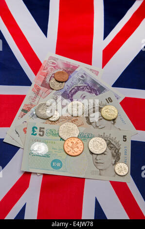 Britische Pfund-Noten und Münzen auf eine Union Jack-Flagge Stockfoto