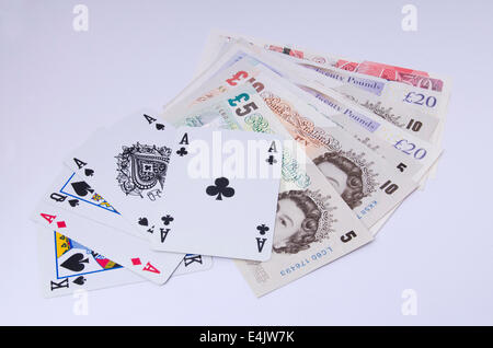 Britische Pfund-Noten mit Spielkarten auf weißem Hintergrund Stockfoto