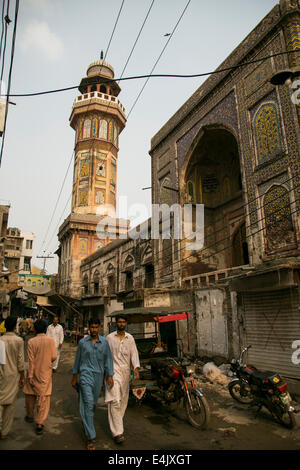 Menschen auf der Straße mit Wazir Khan Moschee dahinter in Lahore Stockfoto