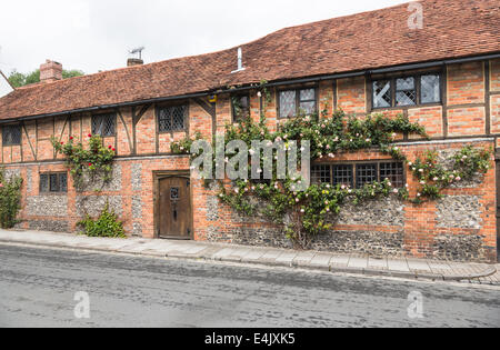 Aus rote Backstein gebaut Fachwerkhaus terrassenförmig angelegten Häuser in Henley-on-Thames, Oxfordshire, Vereinigtes Königreich, mit hübschen rosa Rosen rund um das Fenster Stockfoto