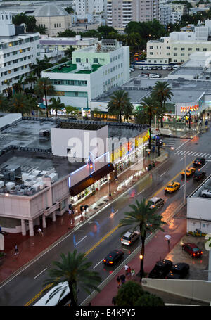 Draufsicht von Geschäften, Gebäuden und Autos auf der Collins Avenue an einem dunklen, regnerischen Nachmittag in South Beach, Miami, Florida. Stockfoto